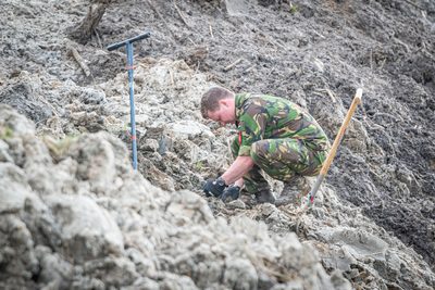 Het is vrijdagmiddag. Het is druk op de snelweg. Met loeiende sirenes is Steenwijker Emiel Snip onderweg vanuit Soesterberg naar de Kop van Overijssel. Hij werkt bij de EOD en vliegt af op een melding uit Steenwijk, die PRIO 1 heeft meegekregen. „Toen ik je de vorige keer sprak, zei ik toch dat ik zou bellen als ik een melding in de buurt zou hebben? Nou…” Een dikke grijns. Er valt een stilte. „Je raadt het al”, zegt hij. „Ik rij nu in de omgeving van Nijkerk. Er is waarschijnlijk een explosief gevonden in het Kornputkwartier. Ik meld me weer als ik bij het politiebureau in Steenwijk ben geweest.”